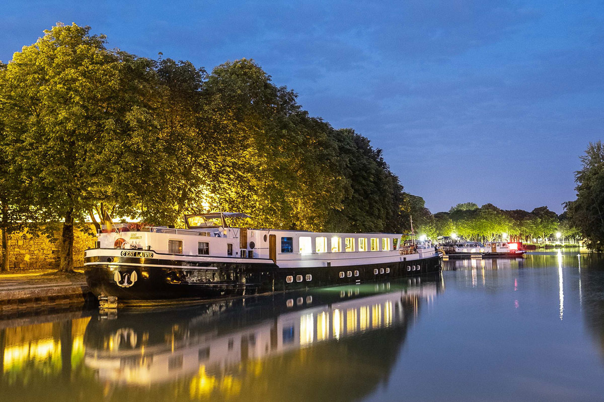 C'est La Vie Luxury Hotel Barge docked in the evening